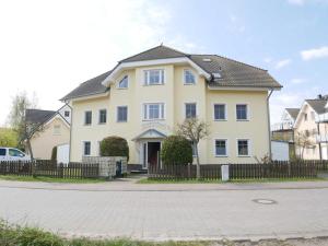 una grande casa gialla con tetto nero di Bernsteinhaus Wohnung 3 mit 2 Balkonen & Kamin a Kolpinsee
