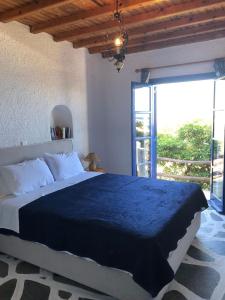 een slaapkamer met een groot bed en een groot raam bij Villas Kalafatis Apartments in Kalafatis
