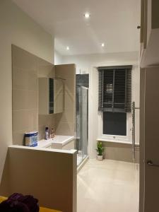 a large bathroom with a shower and a sink at London Central 2 minutes away from train station in London