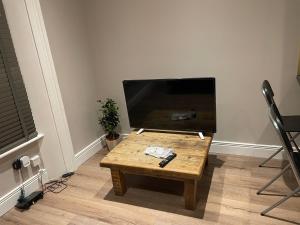 a living room with a table and a flat screen tv at London Central 2 minutes away from train station in London