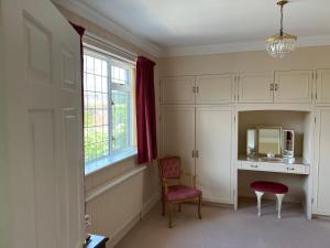 Habitación con escritorio, silla y espejo. en Spacious bungalow with large private garden en Hilperton