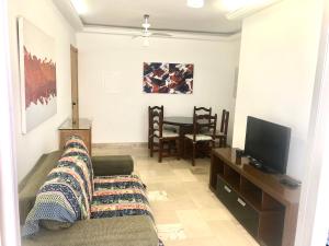sala de estar con sofá y TV en Apartamento Nota 10, en Guarujá