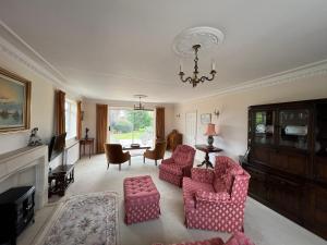 uma sala de estar com duas cadeiras e um lustre em Spacious bungalow with large private garden em Hilperton