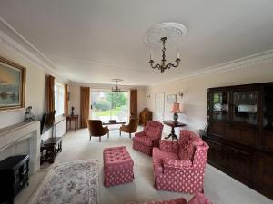 a living room with two chairs and a chandelier at Spacious bungalow with large private garden in Hilperton