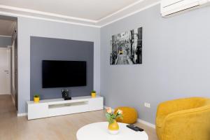 ein Wohnzimmer mit einem TV und einem Stuhl in der Unterkunft Apartman R&B in Zadar