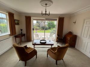 uma sala de estar com uma mesa e duas cadeiras em Spacious bungalow with large private garden em Hilperton
