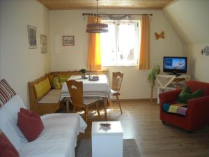 a living room with a table and a couch at Ferienhof Biber in Witzmannsberg