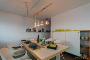 a kitchen with a table with chairs and lights at Seafront Holiday House on the Mindelo Bay in Mindelo +22 photos