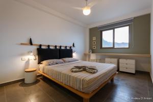 um quarto com uma cama grande num quarto com uma janela em Seafront Holiday House on the Mindelo Bay em Mindelo