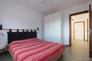 ein Schlafzimmer mit einem Bett mit einer roten gestreiften Decke in der Unterkunft Seafront Holiday House on the Mindelo Bay in Mindelo