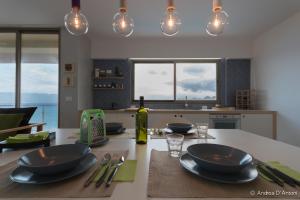 a kitchen with a table with plates and utensils at Seafront Holiday House on the Mindelo Bay in Mindelo