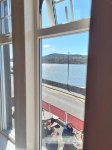a group of people sitting at a table looking out a window at The Anchor Hotel in Kippford