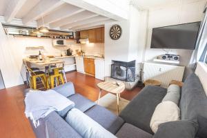 uma sala de estar com um sofá e uma cozinha em La Cabane du Cerf à Payolle em Campan