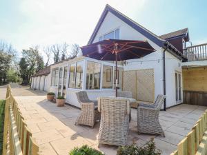 a patio with a table and chairs and an umbrella at Deer View in Witney