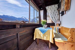 een tafel en een stoel op een balkon met uitzicht op de bergen bij Gästehaus Angela in Garmisch-Partenkirchen