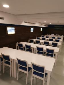 a conference room with white tables and blue chairs at Hotel Boutique Arha Villa de Santona in Santoña