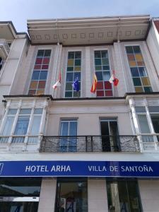a building with flags in front of it at Hotel Boutique Arha Villa de Santona in Santoña