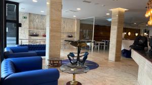 a lobby with blue couches and a table and a bar at Hotel Boutique Arha Villa de Santona in Santoña