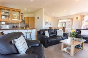 uma sala de estar com sofás de couro e uma mesa em Finest Retreats - Serendipity Lodge em Torpoint