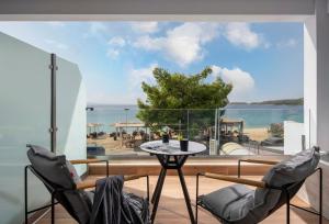 a balcony with a table and chairs and a view of the ocean at Casa Anastasia premium stay in Toroni
