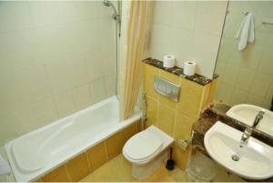 a bathroom with a toilet and a tub and a sink at Marina BestView 2 BedRoom Apartment in Dubai