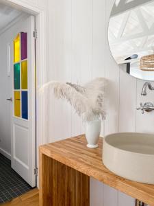 a bathroom with a sink and a vase on a counter at Ragnar Glamp Milzkalne Forest House in Rauda