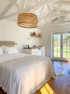 a bedroom with a large white bed and a kitchen at Ragnar Glamp Milzkalne Forest House in Rauda +34 photos
