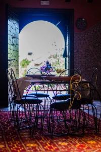 mesa y sillas en una habitación con ventana en riad lala fatima, en Ouzoud