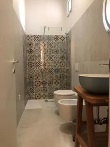 une salle de bain avec un lavabo, des toilettes et une douche dans l'établissement Guido's City Rooms, à Alghero