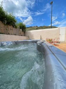 uma banheira de hidromassagem numa piscina em Le Pavillon de l'Hermitage - Spa ouvert d'Avril à Octobre em Tain-lʼHermitage