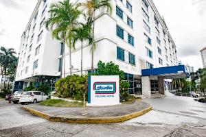 una señal frente a un edificio con una palmera en Studio Coliving Hotel en Panamá