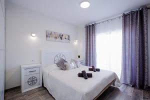 um quarto branco com uma cama e uma janela em Palm Mar de LUX A31 em Palm-mar