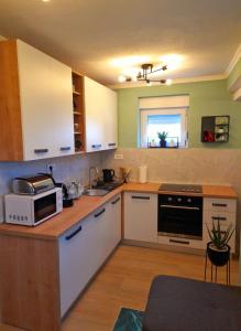 a kitchen with white cabinets and a microwave at Apartman Sunny Lika in Gospić