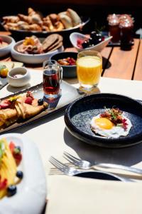 - une table avec des assiettes de produits pour le petit-déjeuner et des boissons dans l'établissement LeCrans, à Crans-Montana