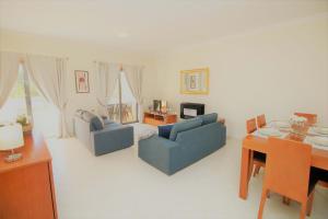 Apartment Garcas Lounge - By Dalma Portuguesa في ألبوفيرا: غرفة معيشة مع كرسيين ازرق ومكتب