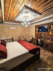 a bedroom with a large bed and a television at Cappadocia Caves Hotel in Göreme