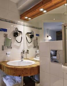 uma casa de banho com um lavatório e 2 espelhos em Le Moulin de Lily em Palaiseau