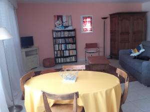 a living room with a table and a couch at LE CALME AU COEUR DE LA VILLE in Nîmes