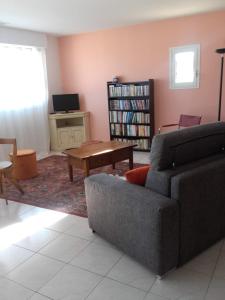 a living room with a couch and a table at LE CALME AU COEUR DE LA VILLE in Nîmes