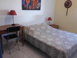 a bedroom with a bed and a desk with a chair at LE CALME AU COEUR DE LA VILLE in Nîmes