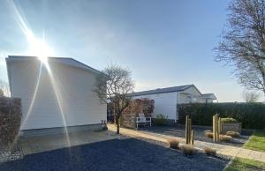 uma garagem branca com o sol a brilhar nela em RBR 813 - Beach Resort Kamperland em Kamperland