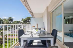 a table and chairs on the balcony of a house at SERRENDY Sea view terrace upscale property in Cannes