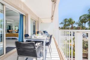 comedor con mesa y sillas en el balcón en SERRENDY Sea view terrace upscale property, en Cannes