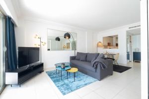 sala de estar con sofá y TV en SERRENDY Sea view terrace upscale property, en Cannes