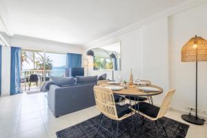 a living room with a table and a couch at SERRENDY Sea view terrace upscale property in Cannes