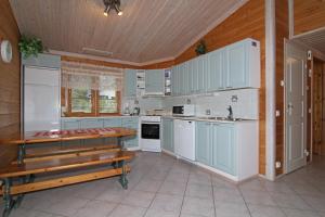 Marjalanranta في يامسا: مطبخ مع دواليب زرقاء وسقف خشبي
