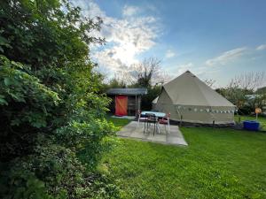 a tent with a table and chairs in a yard at Coutts Glamping in Wadebridge
