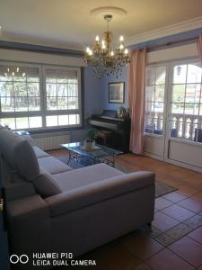 a living room with a couch and a piano at piso chalet en playa samil in Vigo