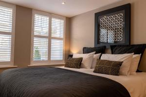 a bedroom with a large bed with two windows at Bath Circle in Bath