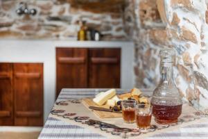 una mesa con dos vasos y una botella de miel y queso en Ligaridia Apartments, en Moutsoúna